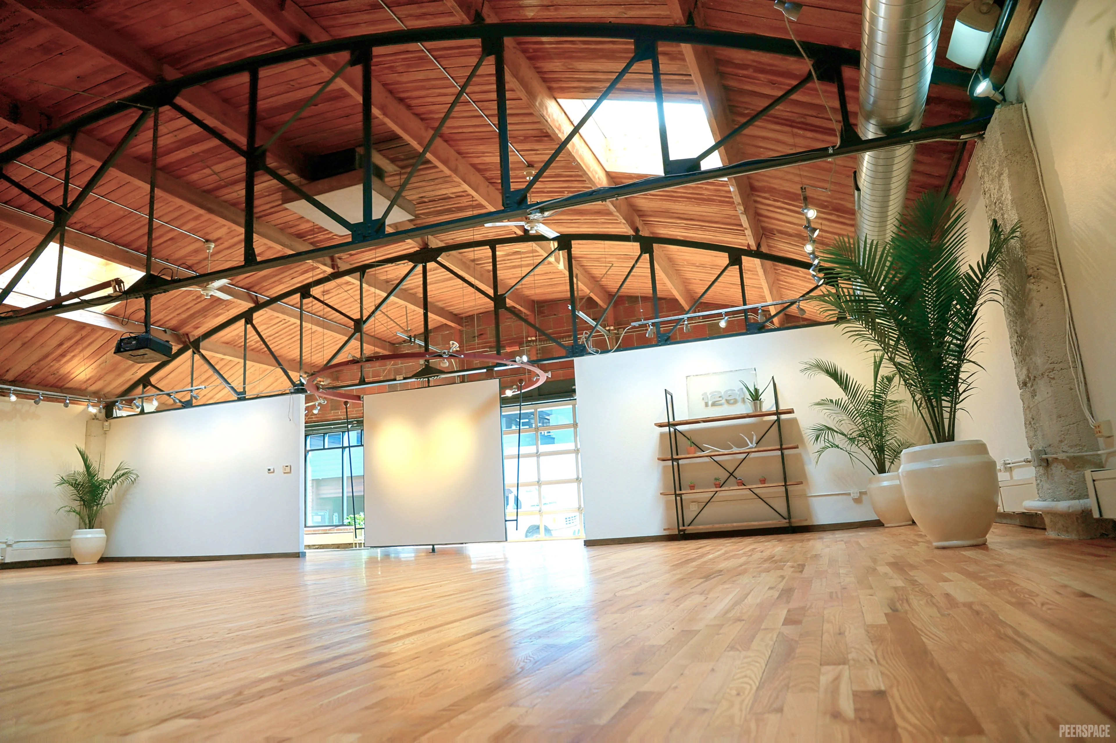 Sterling Event Space empty interior at golden hour, hardwood floors and steel structure visible